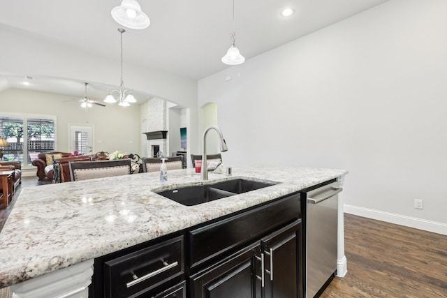 kitchen featuring dark wood-style flooring, a fireplace, a sink, open floor plan, and dishwasher