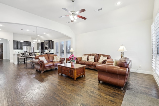 living area with baseboards, visible vents, arched walkways, and dark wood-type flooring