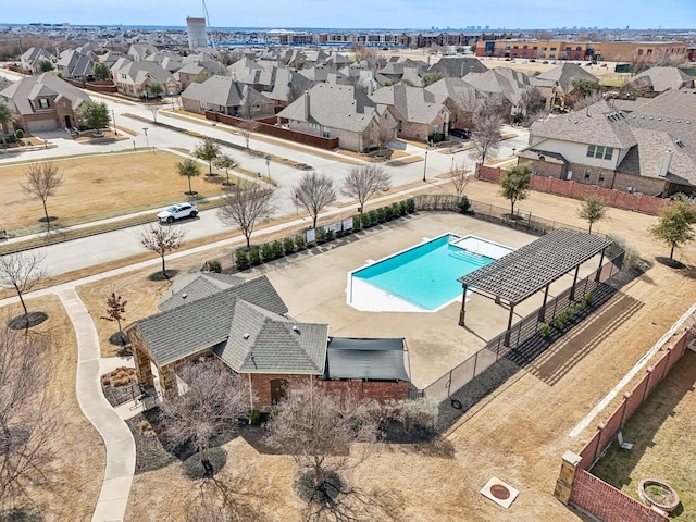 view of swimming pool with a residential view, fence, and a covered structure