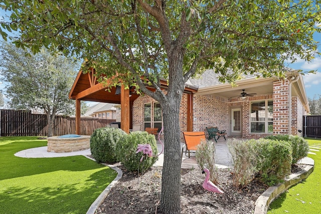 view of yard with ceiling fan, an outdoor fire pit, a patio area, and a fenced backyard