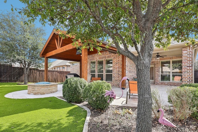 exterior space with a patio area, an outdoor fire pit, fence, and a ceiling fan