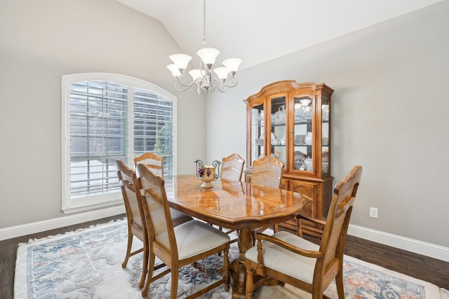 dining space with lofted ceiling, plenty of natural light, wood finished floors, and a notable chandelier