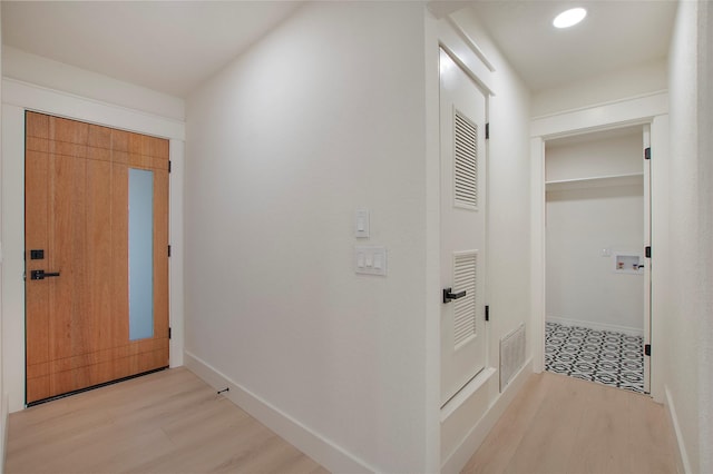 hall with light wood-style flooring, recessed lighting, visible vents, and baseboards