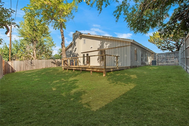 back of house featuring a fenced backyard, a lawn, and a wooden deck