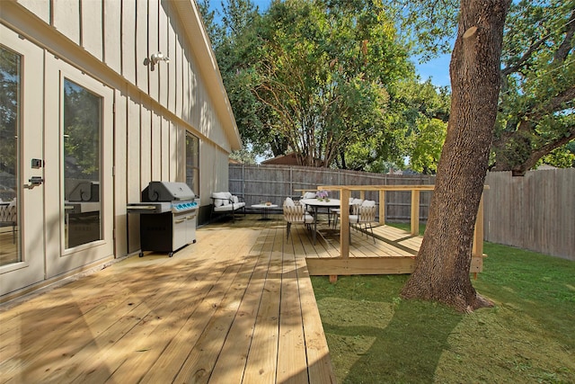 deck featuring a fenced backyard, a lawn, and area for grilling