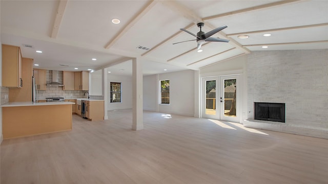 unfurnished living room featuring french doors, visible vents, lofted ceiling with beams, a brick fireplace, and light wood-type flooring