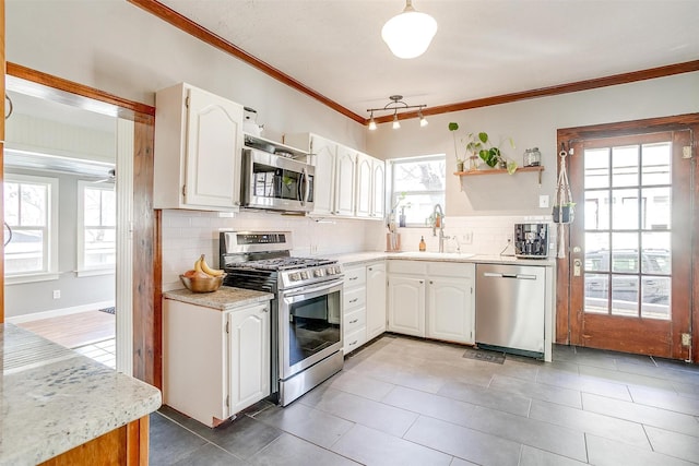 kitchen with appliances with stainless steel finishes, a sink, and white cabinetry