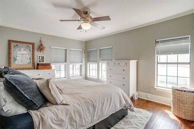 bedroom featuring a ceiling fan, wood-type flooring, ornamental molding, and baseboards