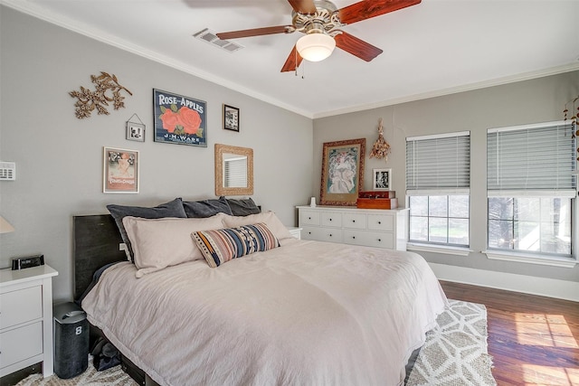 bedroom featuring visible vents, crown molding, and wood finished floors