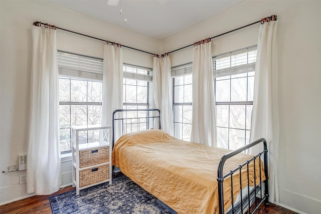 bedroom featuring baseboards, dark wood finished floors, and crown molding