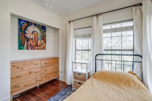 bedroom featuring ornamental molding, multiple windows, and dark wood finished floors