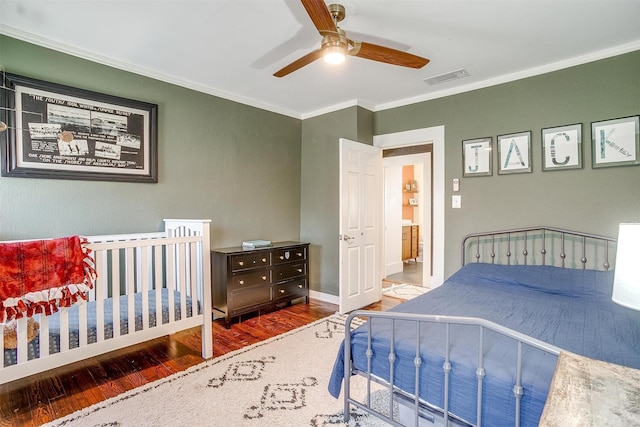 bedroom featuring visible vents, ornamental molding, ceiling fan, wood finished floors, and baseboards