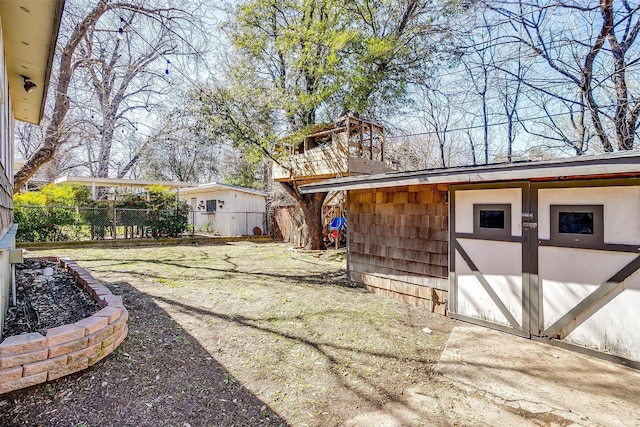 view of yard with an outbuilding and fence