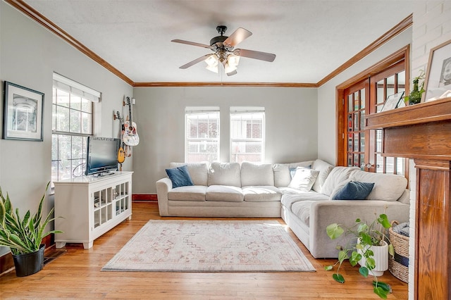 living room featuring a healthy amount of sunlight, ceiling fan, ornamental molding, and wood finished floors