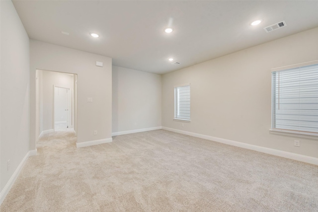 spare room with light carpet, baseboards, visible vents, and recessed lighting