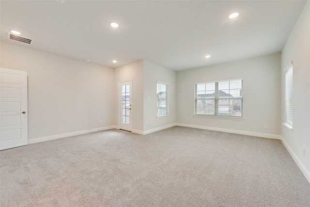 spare room featuring light carpet, visible vents, and recessed lighting