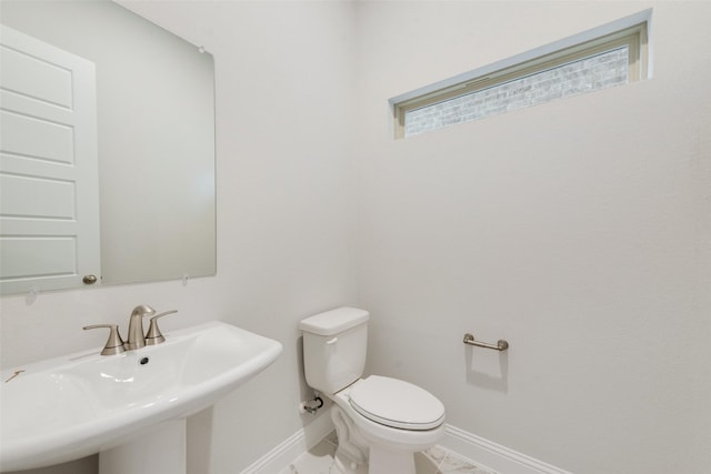 bathroom featuring marble finish floor, a sink, baseboards, and toilet