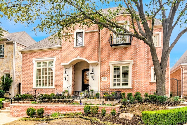 view of front facade featuring a shingled roof and brick siding