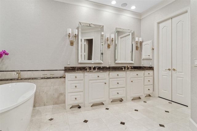 bathroom with double vanity, a freestanding tub, a sink, and crown molding