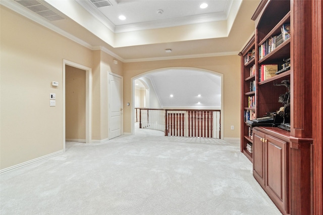 empty room with ornamental molding, a raised ceiling, visible vents, and light carpet