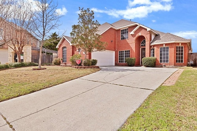 traditional home featuring brick siding, an attached garage, a front yard, fence, and driveway