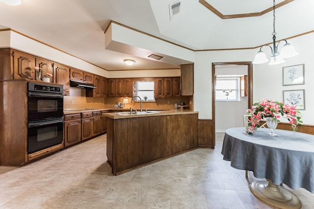 kitchen featuring under cabinet range hood, dobule oven black, a peninsula, a sink, and backsplash