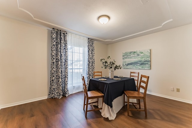 dining space with dark wood-type flooring and baseboards