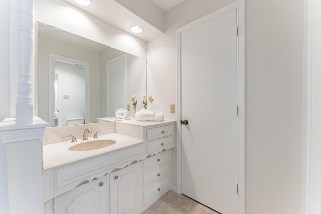 bathroom with toilet, vanity, and ornate columns