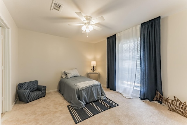 bedroom featuring light carpet, baseboards, visible vents, and a ceiling fan