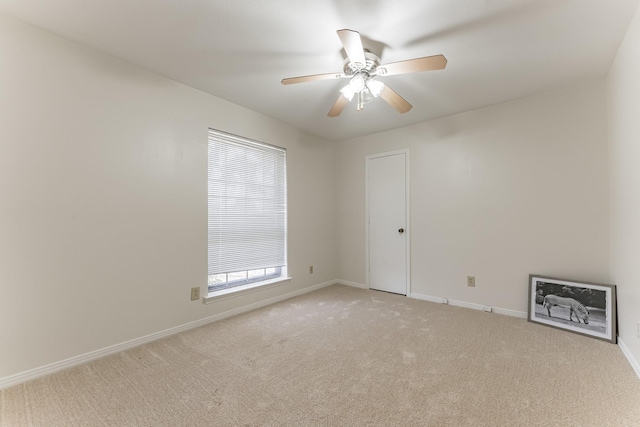 unfurnished room with light carpet, baseboards, and a ceiling fan