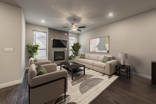 living room with recessed lighting, dark wood-style flooring, a fireplace, and baseboards