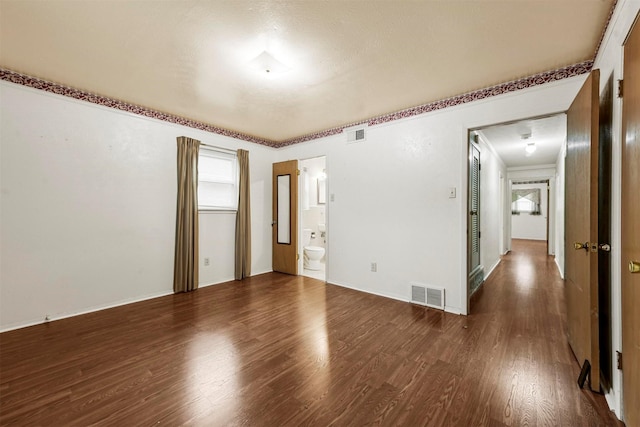 unfurnished room featuring wood finished floors and visible vents