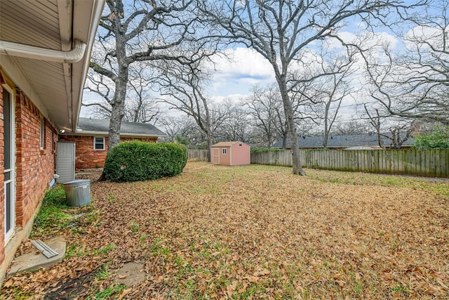 view of yard with a storage shed, an outbuilding, and a fenced backyard