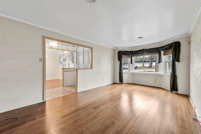 unfurnished living room with wood finished floors and crown molding