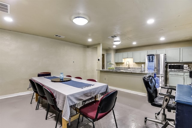 dining area with finished concrete floors and visible vents