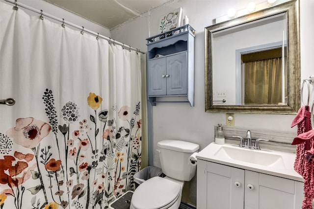 bathroom featuring a shower with shower curtain, vanity, and toilet