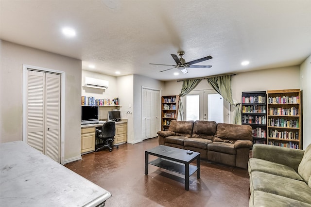 living area featuring french doors, a wall mounted AC, recessed lighting, and finished concrete floors