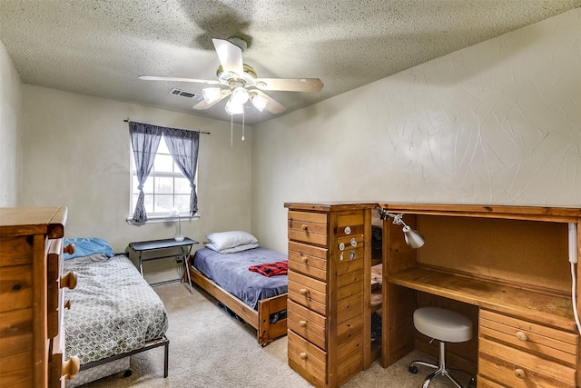 carpeted bedroom featuring visible vents, ceiling fan, and a textured ceiling