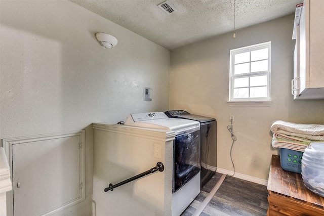 clothes washing area featuring visible vents, cabinet space, a textured ceiling, separate washer and dryer, and baseboards