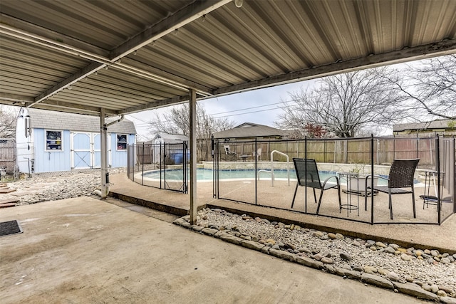 view of patio featuring a fenced in pool, a fenced backyard, and an outdoor structure