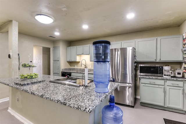 kitchen featuring finished concrete flooring, baseboards, visible vents, light stone countertops, and stainless steel appliances