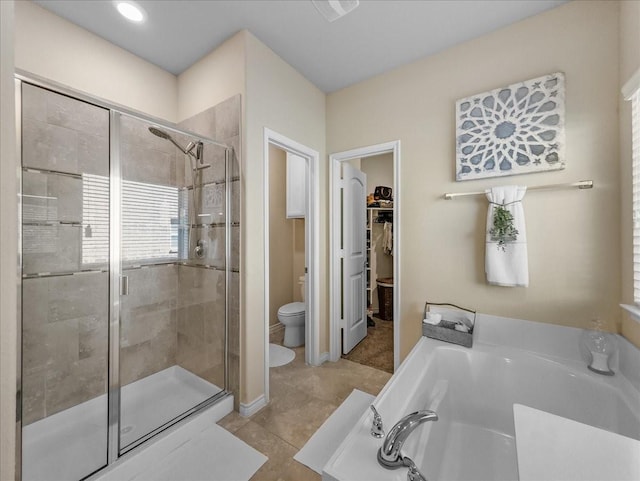 full bath with a garden tub, toilet, a spacious closet, tile patterned floors, and a stall shower