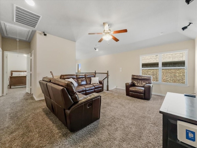 carpeted living area with attic access, visible vents, baseboards, and a ceiling fan