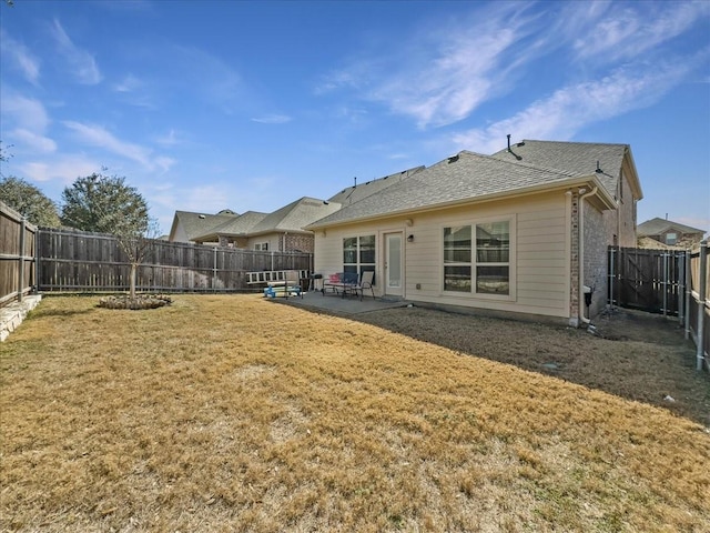 back of property featuring a shingled roof, a fenced backyard, a patio, and a lawn