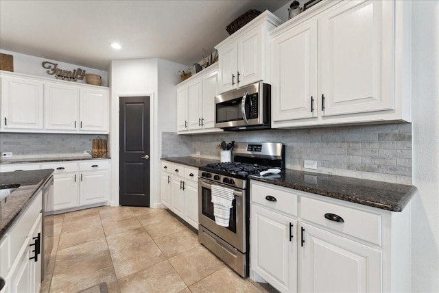 kitchen featuring white cabinets, dark stone counters, and stainless steel appliances