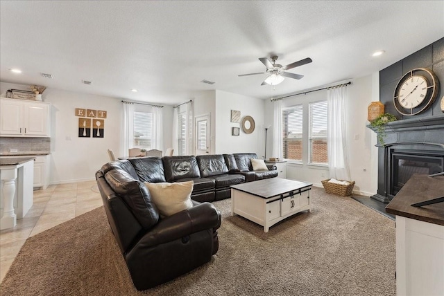 living room featuring a glass covered fireplace, visible vents, recessed lighting, and light tile patterned floors