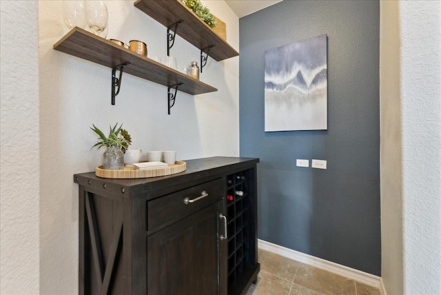 bar featuring baseboards and light tile patterned floors