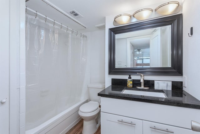 full bathroom featuring visible vents, toilet, shower / tub combo, vanity, and wood finished floors