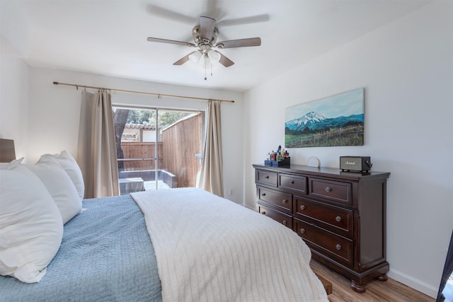 bedroom featuring access to exterior, ceiling fan, baseboards, and wood finished floors