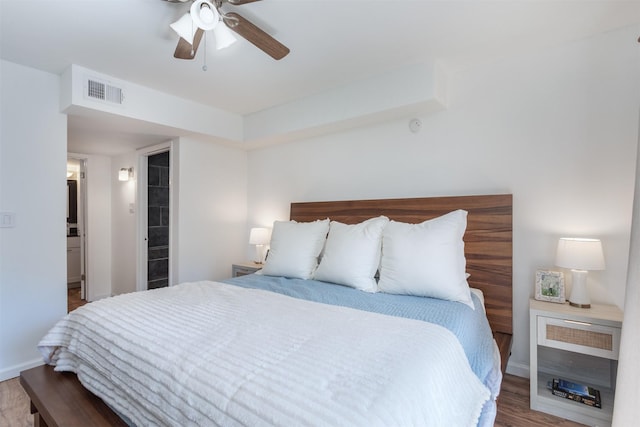 bedroom with ceiling fan, wood finished floors, visible vents, and baseboards